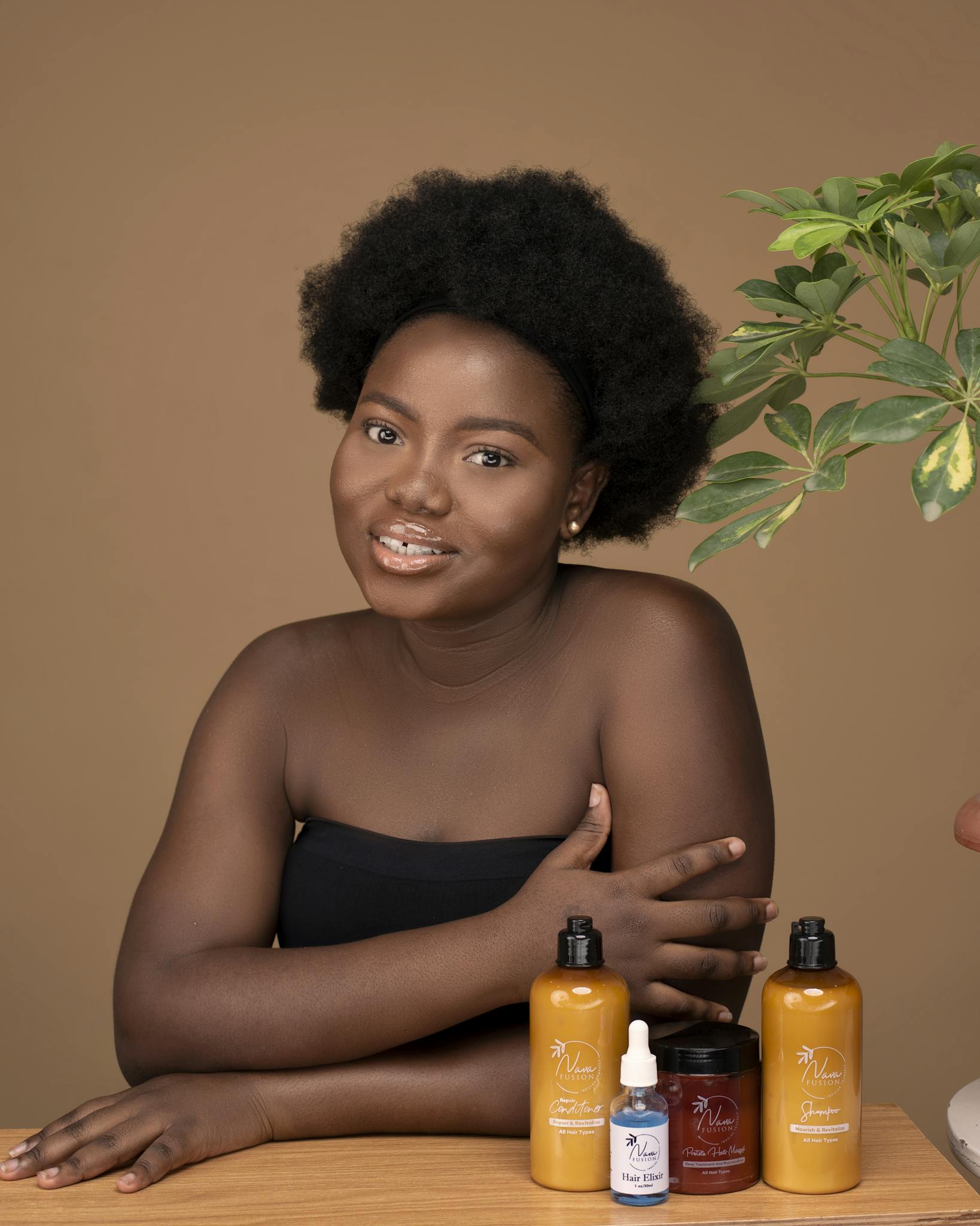 Portrait of a woman with skincare products, studio setting.